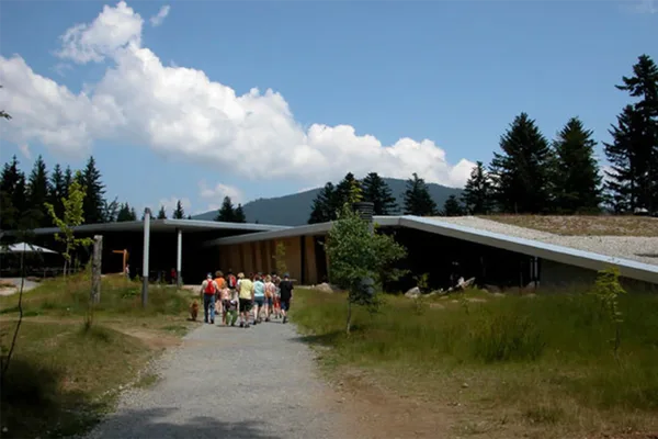 Menschen gehen einen Weg entlang zu Eingang des Haus zur Wildnis.