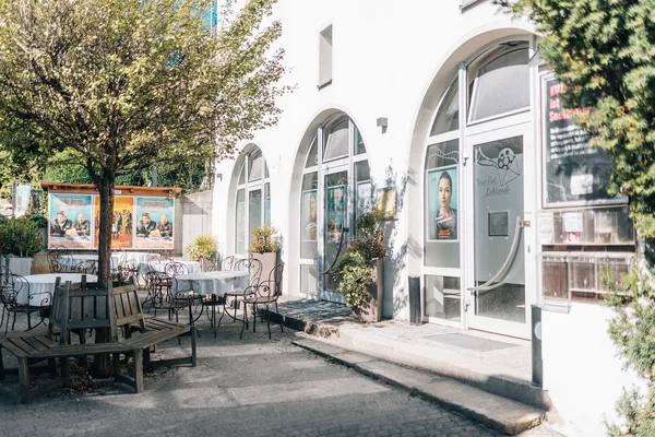 Der Eingangsbereich des Kinos in Viechtach mit kleinen Bäumen und Sitzgelegenheiten.