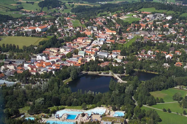 Eine Luftaufnahme von Grafenau. Man sieht das Freibad, zwei Seeen und viele Häuser.