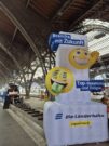 Auf diesem Bild sehen Sie einen großen aufblasbaren Aufsteller an einem Bahnsteig.