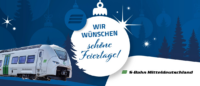 Auf diesem Bild sehen Sie einen Zug vor einem blauen, weihnachtlichen Hintergrund. Auf einer weißen Weihnachtsbaumkugel steht Wir wünschen schöne Feiertage.