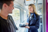 Das Fahrpersonal verkauft direkt im Zug ein Ticket für die Fahrt an einen Kunden.