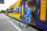 Ab sofort ganzjährig kostenlose Fahrradmitnahme in der oberpfalzbahn und im alex im Landkreis Cham Auf dem Bild sieht man einen Mann, der mit seinem Fahrrad aus der Oberpfalzbahn aussteigt.