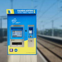 Auf dem Bild sieht man einen Fahrkartenautomaten auf dem Bahngleis.Auto