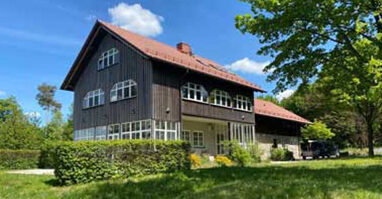 Marktredwitzer Haus Das Marktredwitzer Haus ist im Sonnenschein seitlich zu sehen. Im Vordergrund ist alles voller grüner Hecken, Wiese und Bäume. Der Himmel ist blau.