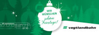 Die vogtlandbahn wünscht frohe Weihnachten Das Bild zeigt ein grün-weißes, weihnachtlich gestaltetes Banner mit dem Text "WIR WÜNSCHEN schöne Feiertage!" in der Mitte, geschrieben auf einem weißen Ornament. Der Hintergrund zeigt Silhouetten von Weihnachtsbäumen, Ornamenten und Sternen. Auf der linken Seite ist die Umrisszeichnung eines Zuges mit dem Text "vogtlandbahn" zu sehen. Auf der rechten Seite befindet sich das Logo und der Name "vogtlandbahn."